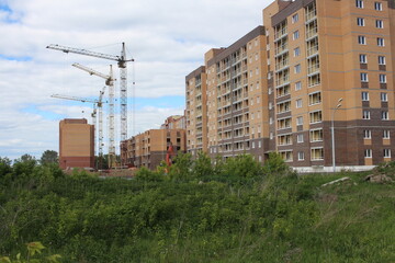 Fototapeta na wymiar Russia, Novosibirsk 10.06.2021: construction of multi-storey modern buildings for the city with houses crane on an industrial site