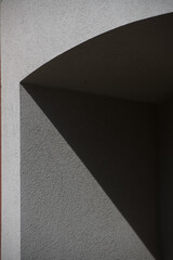 black and grey geometrical shapes created by shadows cast by afternoon sunlight onto concrete doorway of home exterior building textured patterned backdrop or wall paper room or space for type 