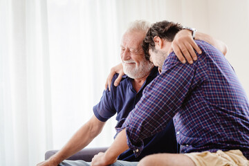 old father elder grateful happy smile and embrace his son at home
