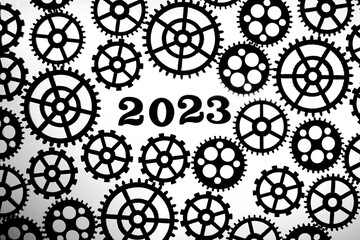 2023 on a background with silhouettes of gears on a white background.Concept progress and movement.