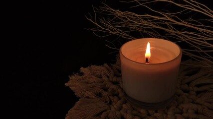 candle burning in dark background. symbolic concept.