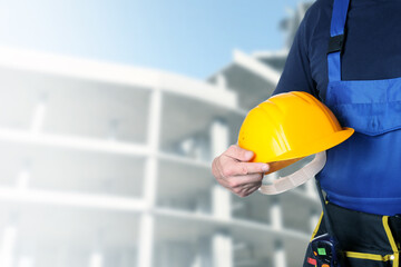 Fototapeta premium Male worker with safety hardhat at construction site