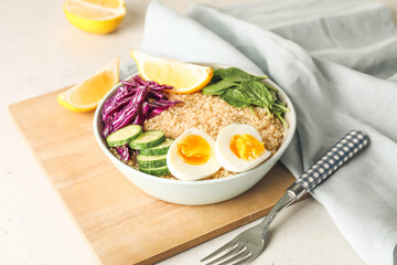 Healthy quinoa bowl with egg on light table