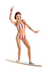 Beautiful young woman with surfboard on white background