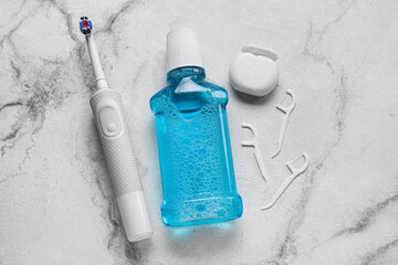 Dental floss with toothpicks, rinse and electric brush on grunge background