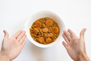 Hands showing plate with lentil stew