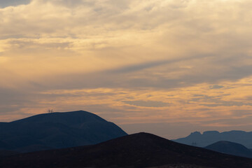 Golden time in cloudy skies and blue mountains