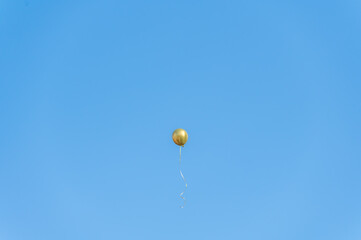 A golden balloon flew under the blue sky and white clouds