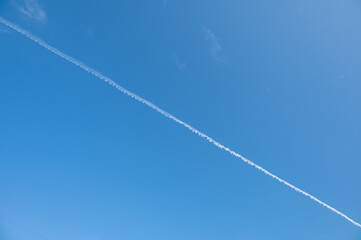 The plane's wake across the sky is like a cloud