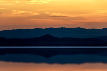 Salt lake and azure mountains at sunset