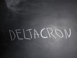New version of covid 19. Deltacron written in chalk on a black board. COVID-19 Deltacron Variant Concept.