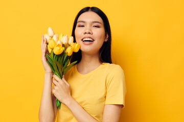 pretty brunette bouquet of flowers in hands spring fun posing yellow background unaltered