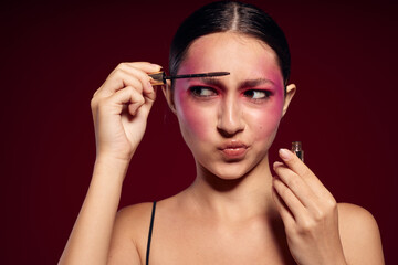 Fototapeta premium fashionable woman Makeup Brush clean leather bright makeup posing pink background unaltered