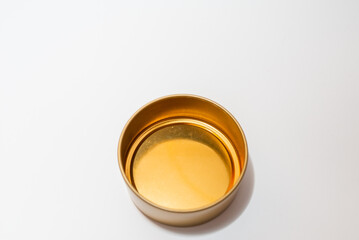 Yellow golden round empty metal box on white background.Soft focus,top view,copy space.
