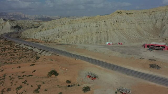 Aerial Of Empty Road And Truck Stop Surrounded By Weathered Hills At Hingol National Park In Balochistan