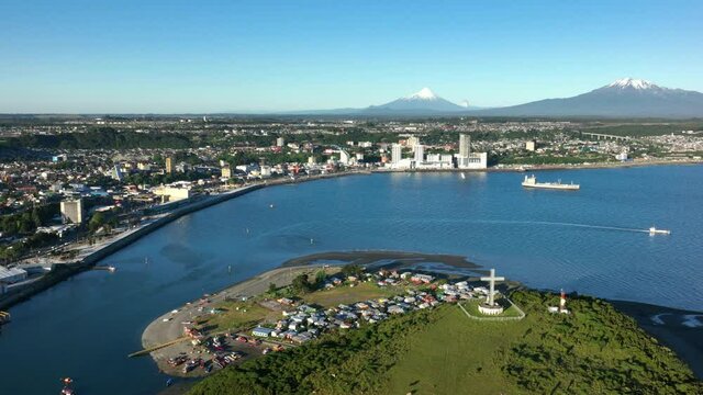 Aerial Over Tenglo Island With Bay Of Puerto Montt With Calbuco Volcano Seen In Distant Background. Dolly Right