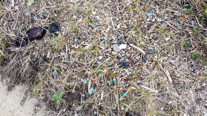 Naklejka na ściany i meble Beach plastic pollution Microplastics on a beach in pollution concept with plastic bits