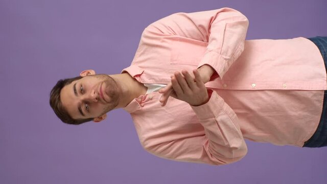 Vertical studio portrait of proud young man clapping in hands, applauding looking at camera on pink isolated background. Happy male nodding in approval, successful good job. Shooting in slow motion.
