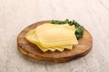 Sliced Gouda cheese over board