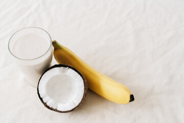 white healthy smoothie made of banana and fresh coconut, in a glass glass. healthy breakfast, healthy lifestyle