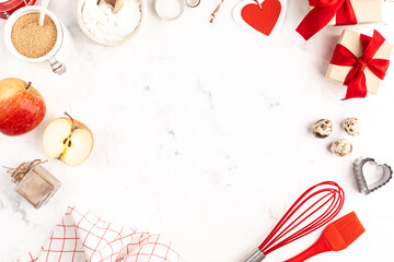 A frame with baking ingredients for Valentine's Day or Birthday, a culinary background with pastries - whisk for whipping, cookie molds, apples, sugar, flour. White background, top view