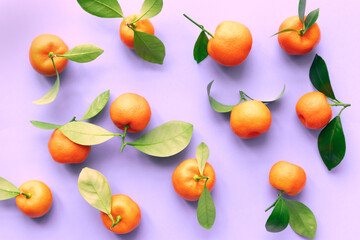 Mandarins with leaves on a lilac background. Flat lay, top view.