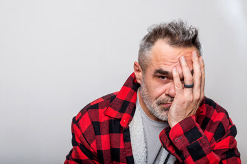 Portrait of a cringe man in a warm buffalo check lumberjack shirt