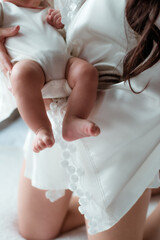 The hands of mom  are holding tiny cute baby feet. Happy motherhood. Healthy lifestyle 