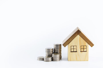 Money allocation and financial planning for future home purchases or success in real estate investment. Row coins and wooden houses on white background. with copy space