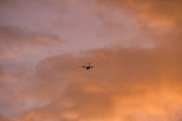 Plane in the evening sky in luminous horizon. It goes on vacation