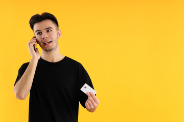 Young man talk on phone on yellow background