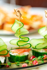 Festive canapes with salmon and cucumber in the form of a Christmas tree on a family holiday table. Banquet, buffet