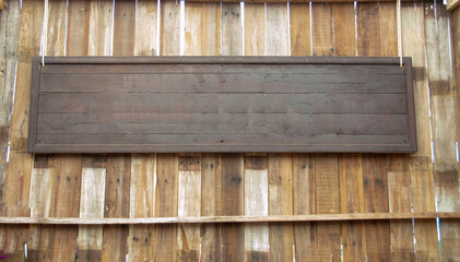 Brown wooden sign hanging on the wall.
