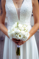 bride in a white dress with a beautiful white bouquet of peonies