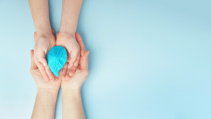 hands are holding a drop of water on a blue background