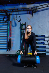 Young woman goes in for sports in the gym. The concept of sports, fitness training. Woman Performs Heavy Weight Exercises