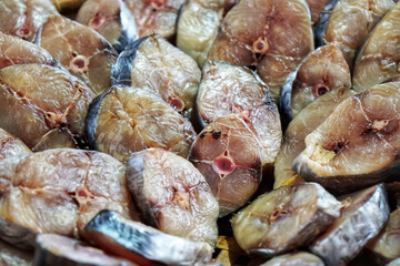 Group of dried salt fish. Many pieces arranged in basket for sell in market.