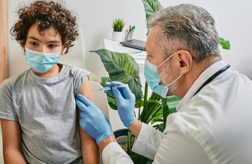 Male child during vaccination in doctor's office. Vaccination of children while a global pandemic