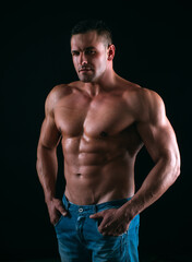 Fototapeta na wymiar Sexy man on black. Handsome fitness young bodybuilder with naked torso.