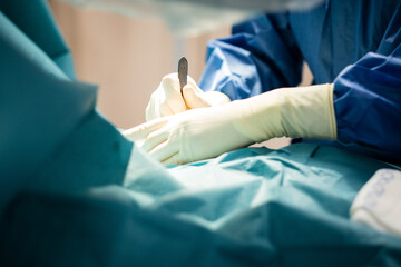 Obraz na płótnie Canvas Operation in einem Krankenhaus - Eine Ärztin hält ein Skalpell