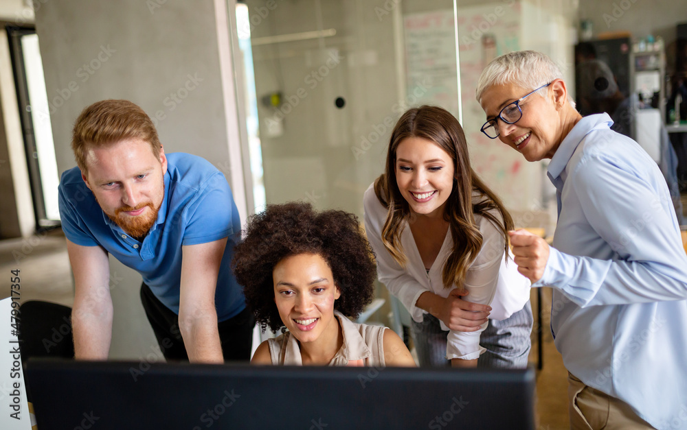 Wall mural group of software engineers working developing applications together in corporate office