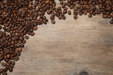 Fototapeta premium Many roasted coffee beans on wooden table, flat lay. Space for text