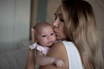 young beautiful woman kisses her little cute daughter. family portrait