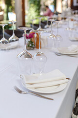 Tables set for meal. Plate, wine glasses and cutlery on a banquet server table with a white tablecloth in a luxury restaurant