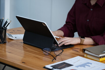 A female company employee is using a tablet computer to search the Internet for information.