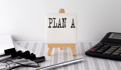 text PLAN A on easel with office tools and paper.Top view. Business concept