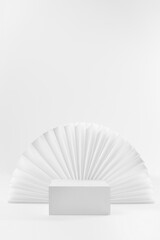 White box podium on abstract scene mockup as showcase for presentation cosmetic product, goods with asian round white ribbed paper fan as frame in simple minimalistic style, vertical, copy space.