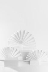Abstract white stage mockup with three rectangle podiums on table for showing, presentation cosmetic product, goods with  light paper fans, arch in fashion style, front view, vertical, copy space.