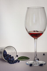 Sweet cherry syrup in a glass with honeysuckle berries, green cherry leaf. Selective focus, copy space, low key