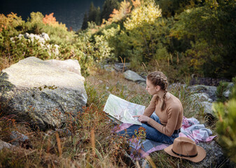 Young woman on a hiking trip sitting on a rock